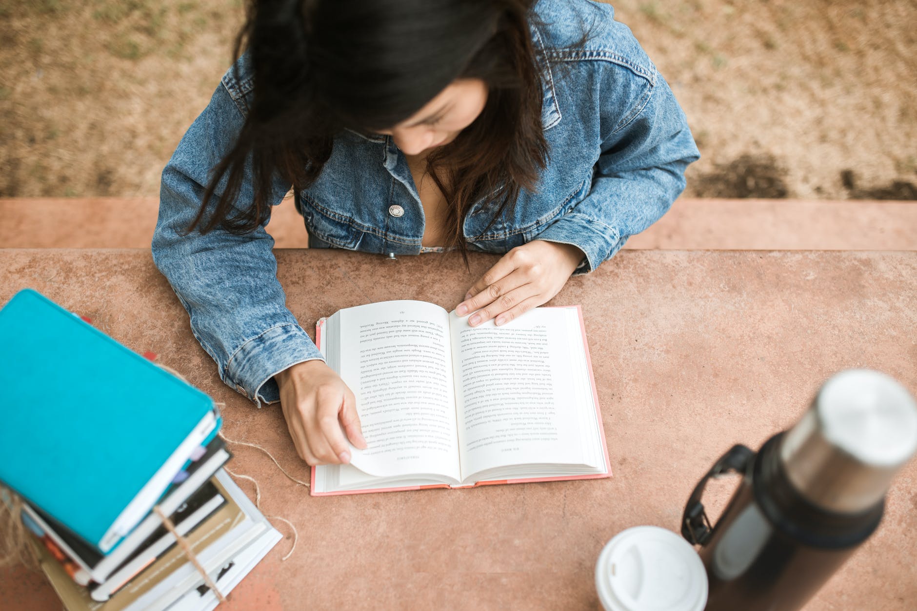 woman in blue denim jacket reading book